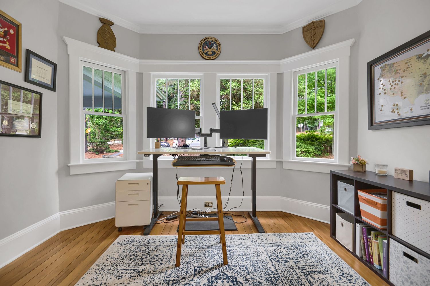 Cozy sitting area with bay windows, hardwood floors, and built-in bookshelves.