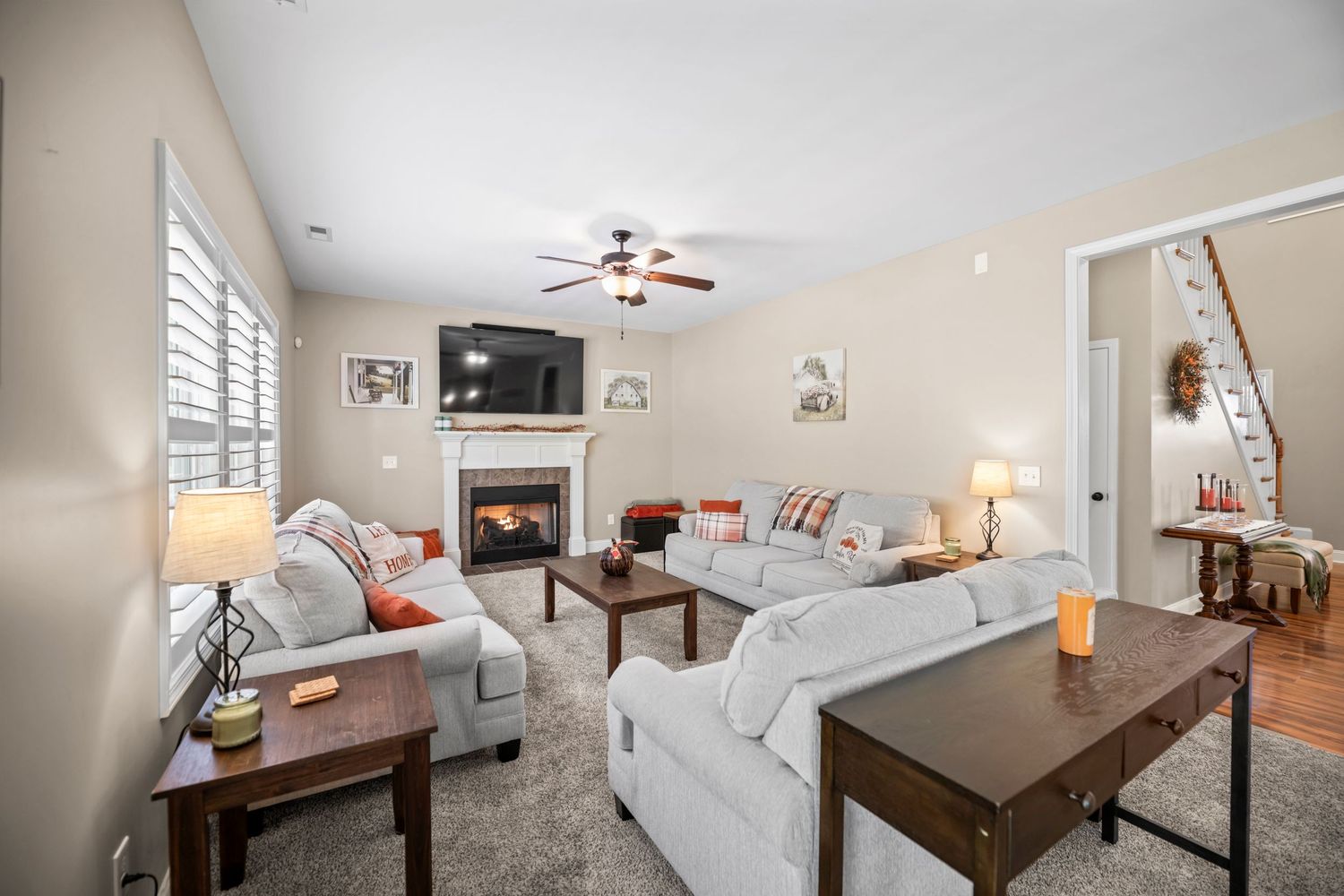 Modern living room with white furniture, hardwood floors, and contemporary decor.