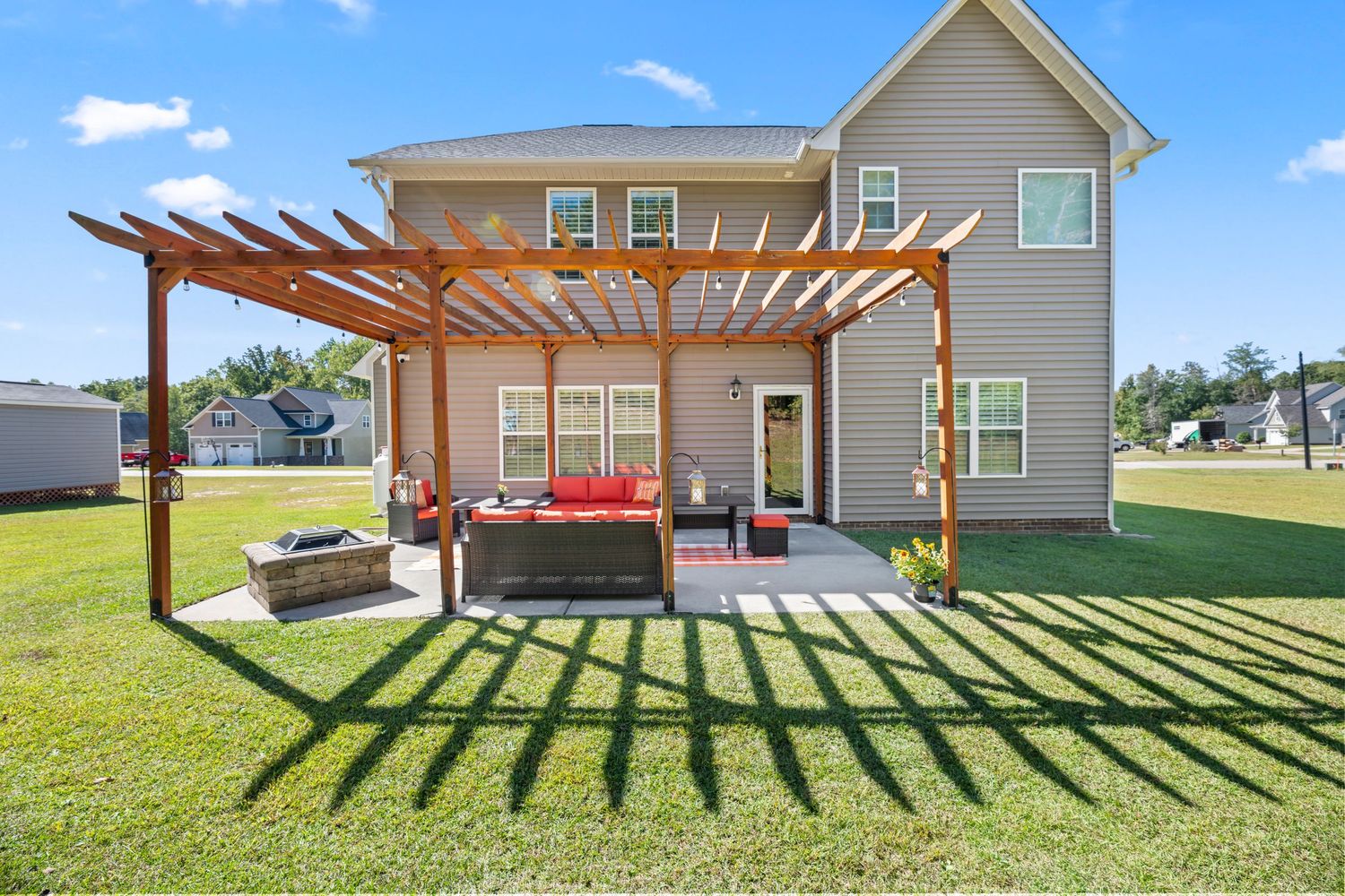 Exterior view of a single-story home with covered patio and well-maintained lawn.