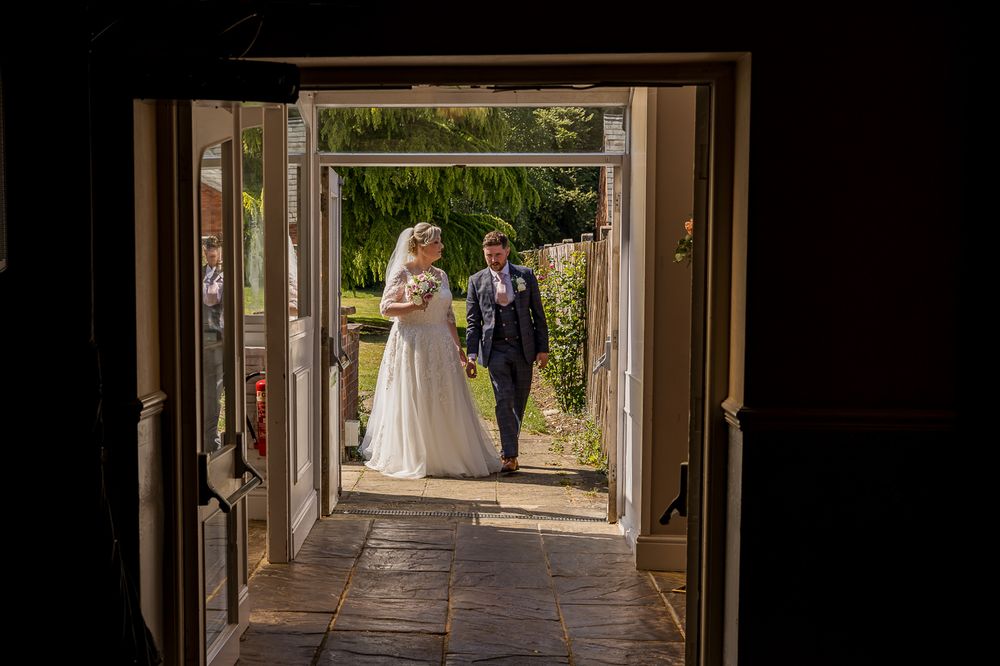 View through doorway of outdoor garden path with stone columns.