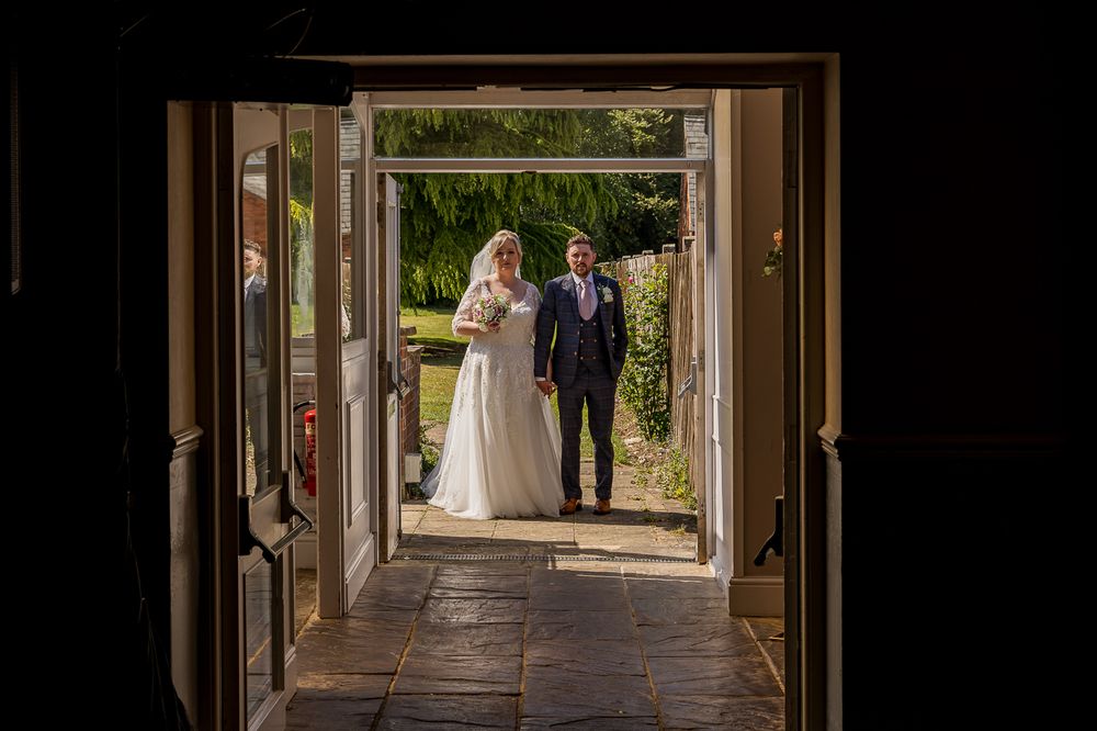 Framed view through doorway of garden walkway with stone columns.