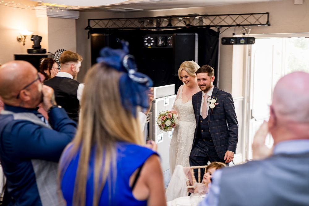 Wedding guests watch and record a special moment during the reception in an elegant indoor venue.