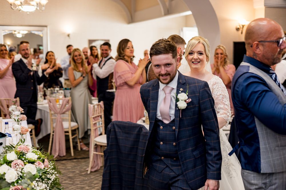 Wedding celebration in full swing as guests applaud during a joyous moment in an elegant reception hall.