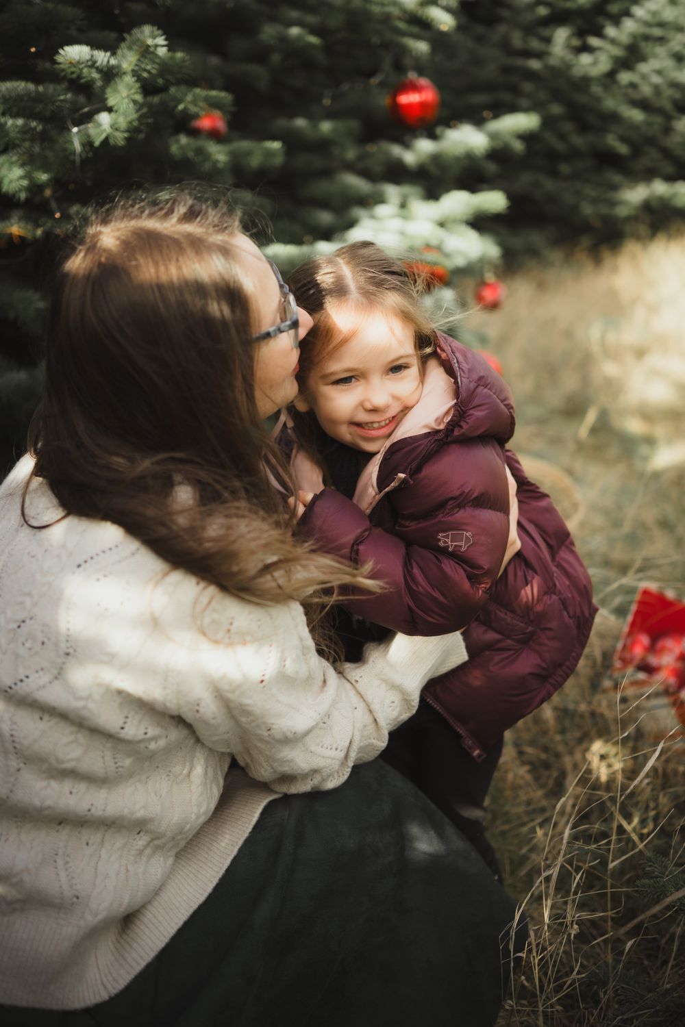 Two people share an intimate moment outdoors surrounded by greenery and red decorative elements.
