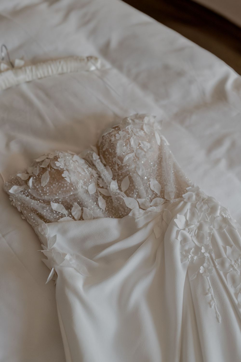 Das Brautkleid leigt beim Getting Ready im KPM Hotel auf dem Bett, damit die Hochzeitsfotografin das Kleid in ihren Details fotografiert.