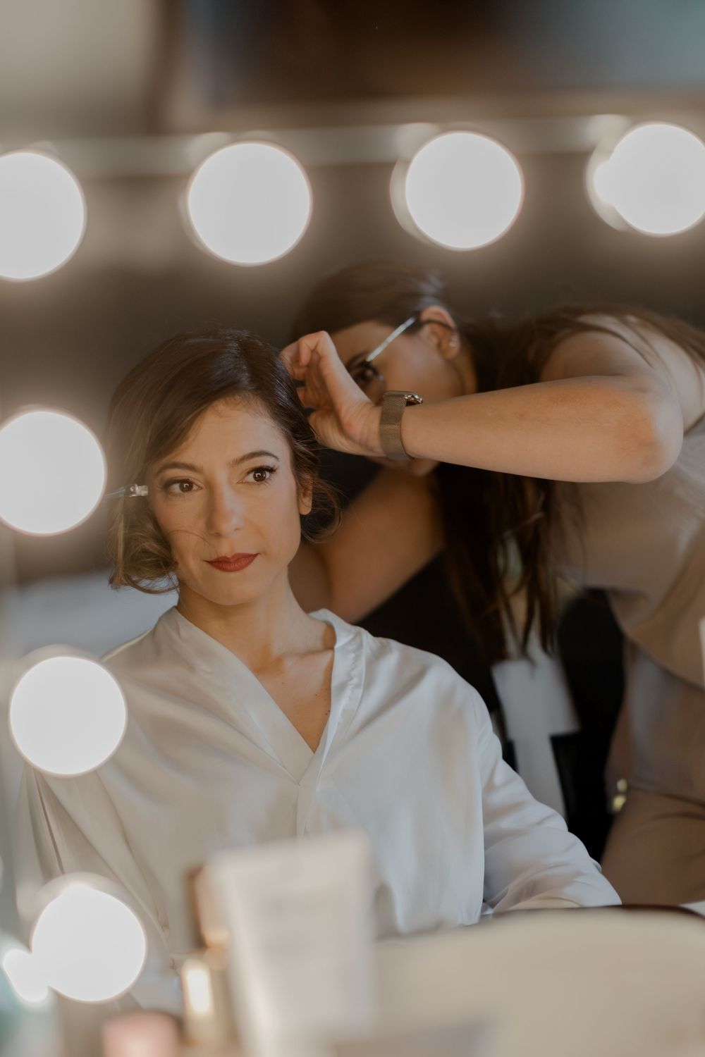 Das Getting Ready der Hochzeit im KPM Hotel beginnt mit dem Styling der Braut vor dem Spiegel. Sie ist emotional und sehr aufgeregt.