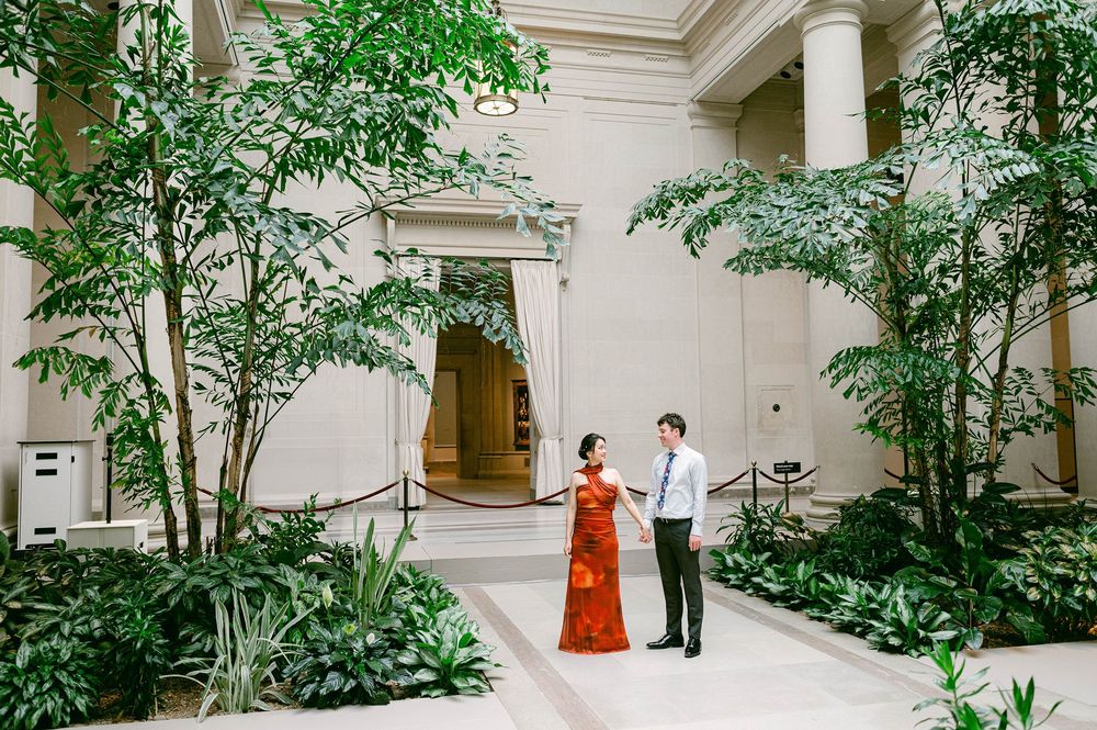 Medical professionals walk through a bright hallway with indoor plants and white walls at a modern healthcare facility.