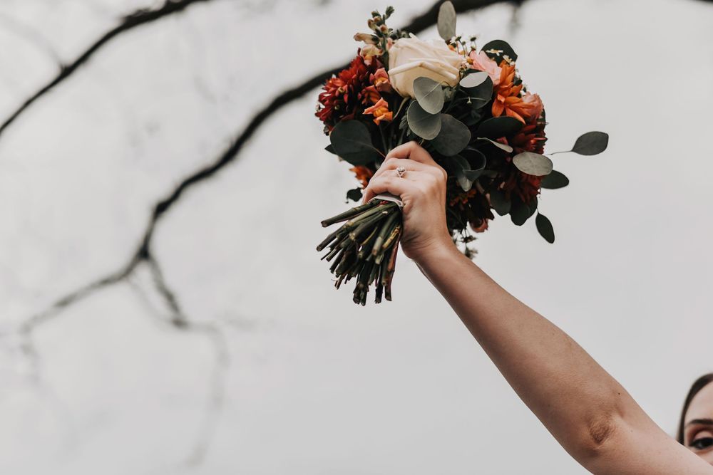 a bride lifts her bouquet in celebration of her wedding