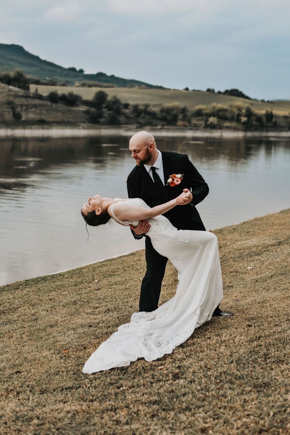 a fun and editorial dip between a husband and his wife as they celebrate their wedding at the river's edge wedding venue