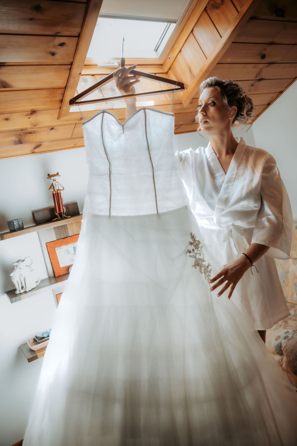 A bride in a white ballgown wedding dress twirls and spins to show off the full skirt in a rustic wooden room.