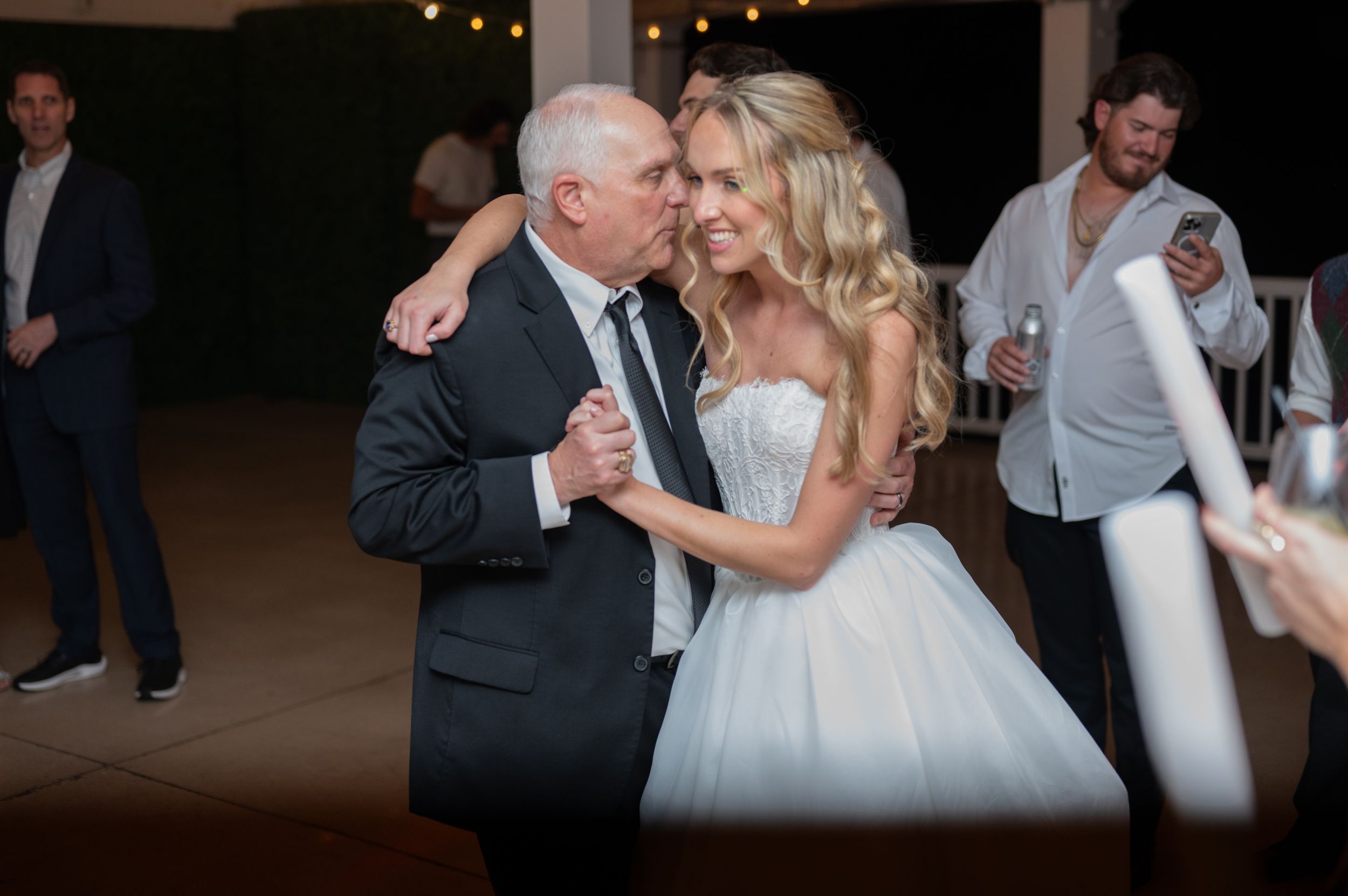 A series of candid dance floor moments at a wedding reception with guests celebrating under dim lighting.
