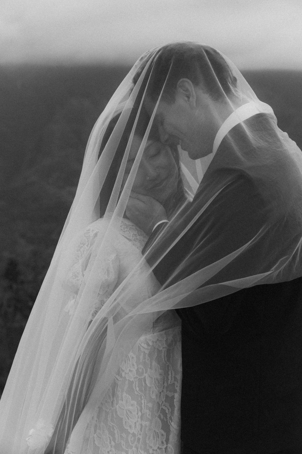 A series of black and white photographs showing a delicate wedding veil blowing in the wind against a dark background.