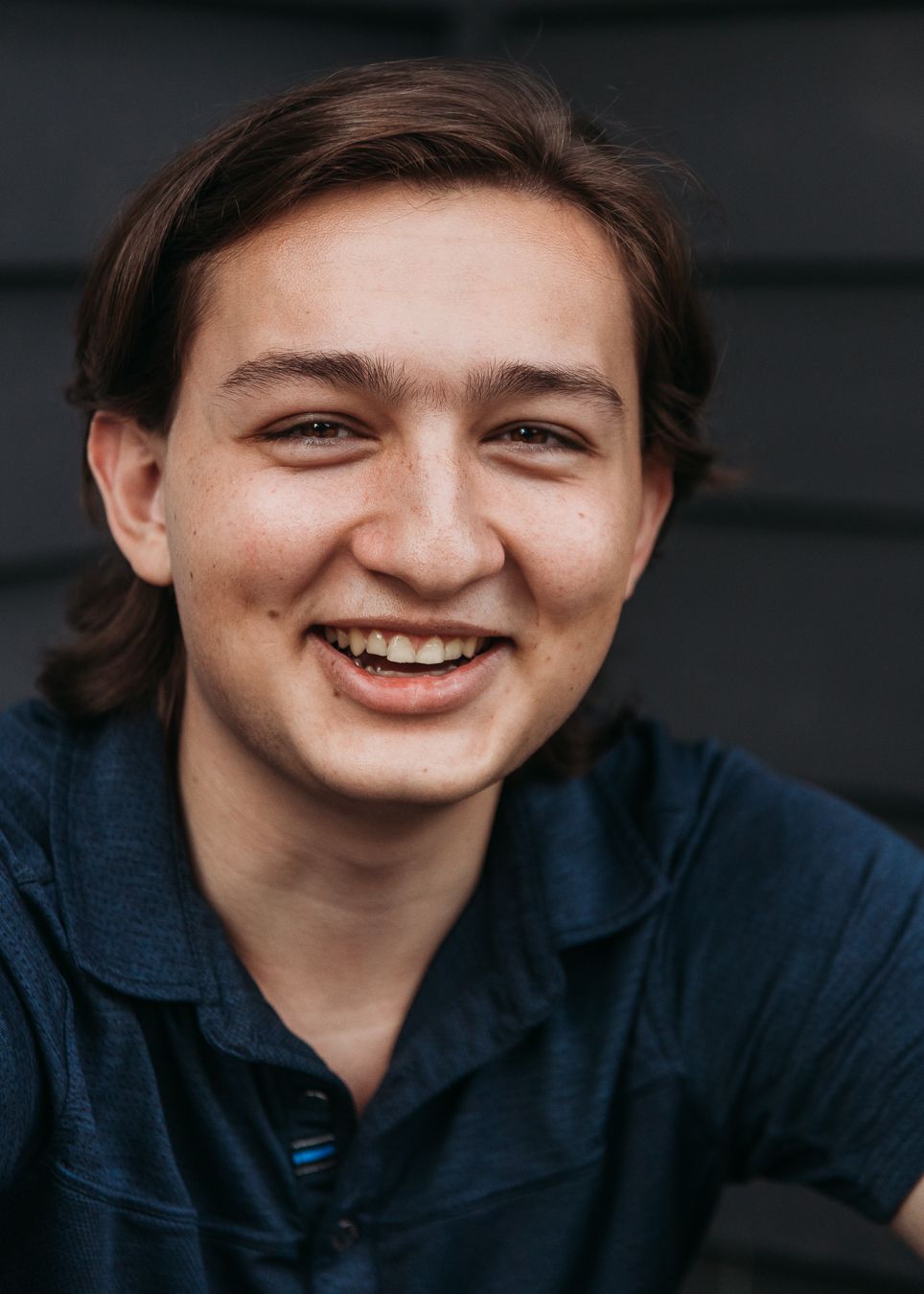 A series of five close-up portraits showing joyful expressions and genuine smiles against a dark background.