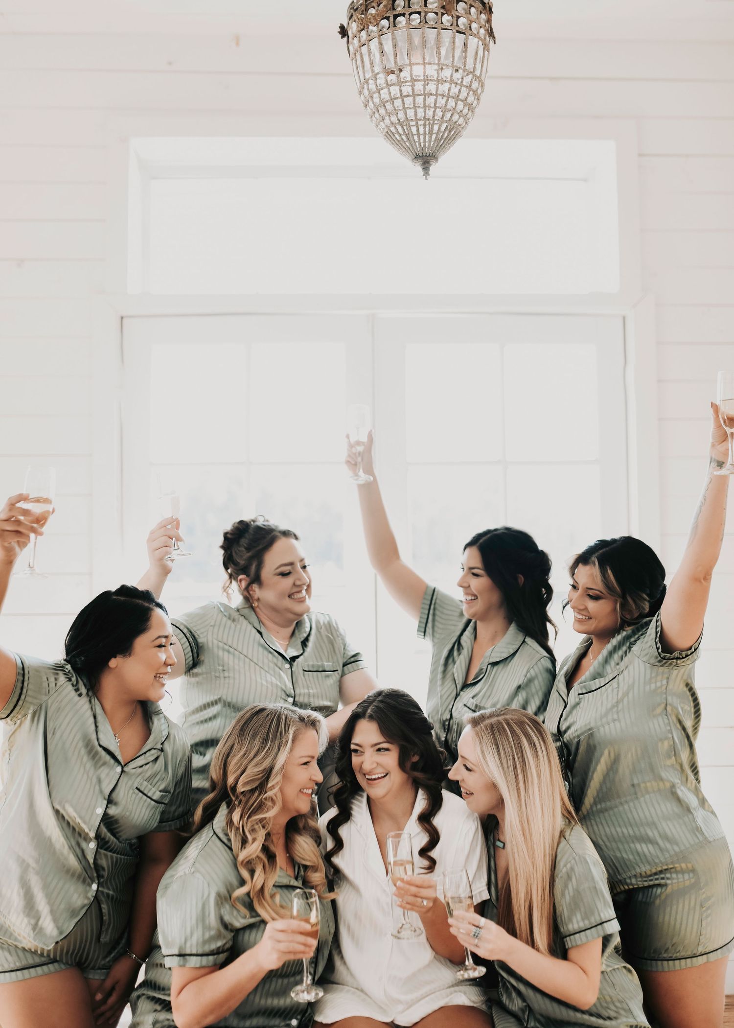 bridal party in matching pjs toast before the wedding