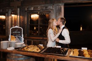 A cozy rustic barn wedding reception features soft lighting and wooden beams creating a romantic ambiance.