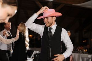Wedding guests dance together during an evening reception celebration on the dance floor.