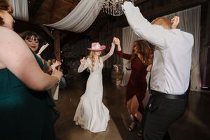 Wedding guests dance together on the dance floor during a reception celebration.