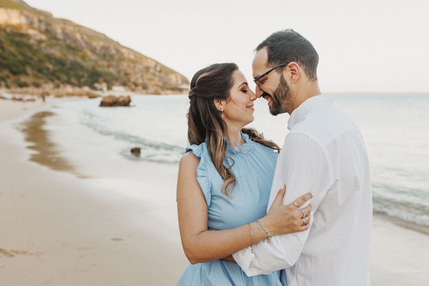 Beach pre-wedding photos in Arrábida with couple walking by the ocean