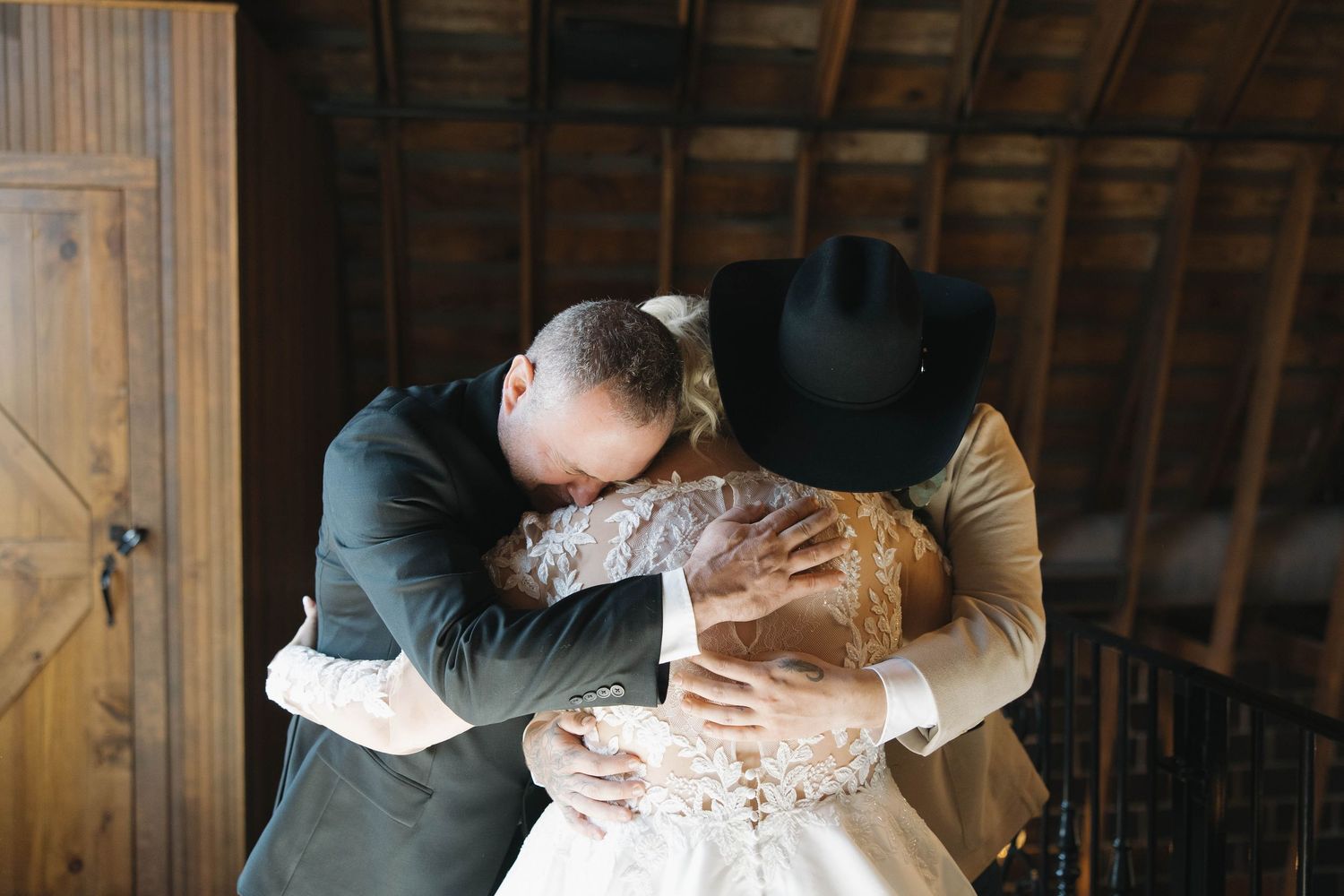 Intimate moment captured in a rustic barn setting during a wedding celebration.