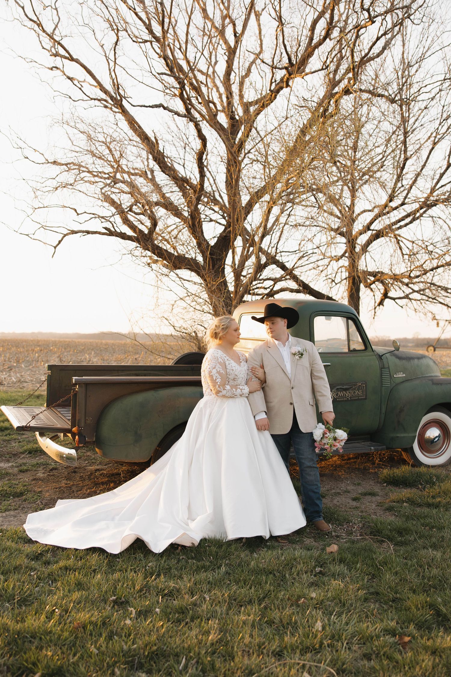 A romantic wedding photo series featuring a couple posing with a vintage green truck in a rustic outdoor setting at sunset.