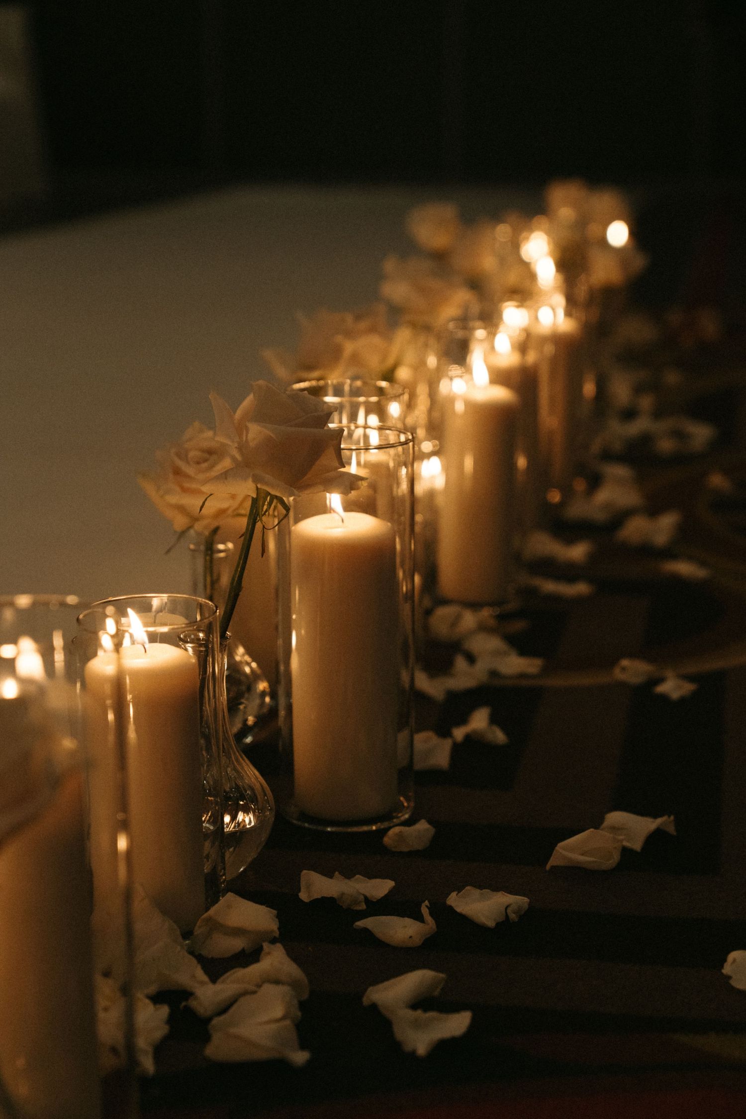 A row of lit candles on a dark background, creating a warm and cozy atmosphere.