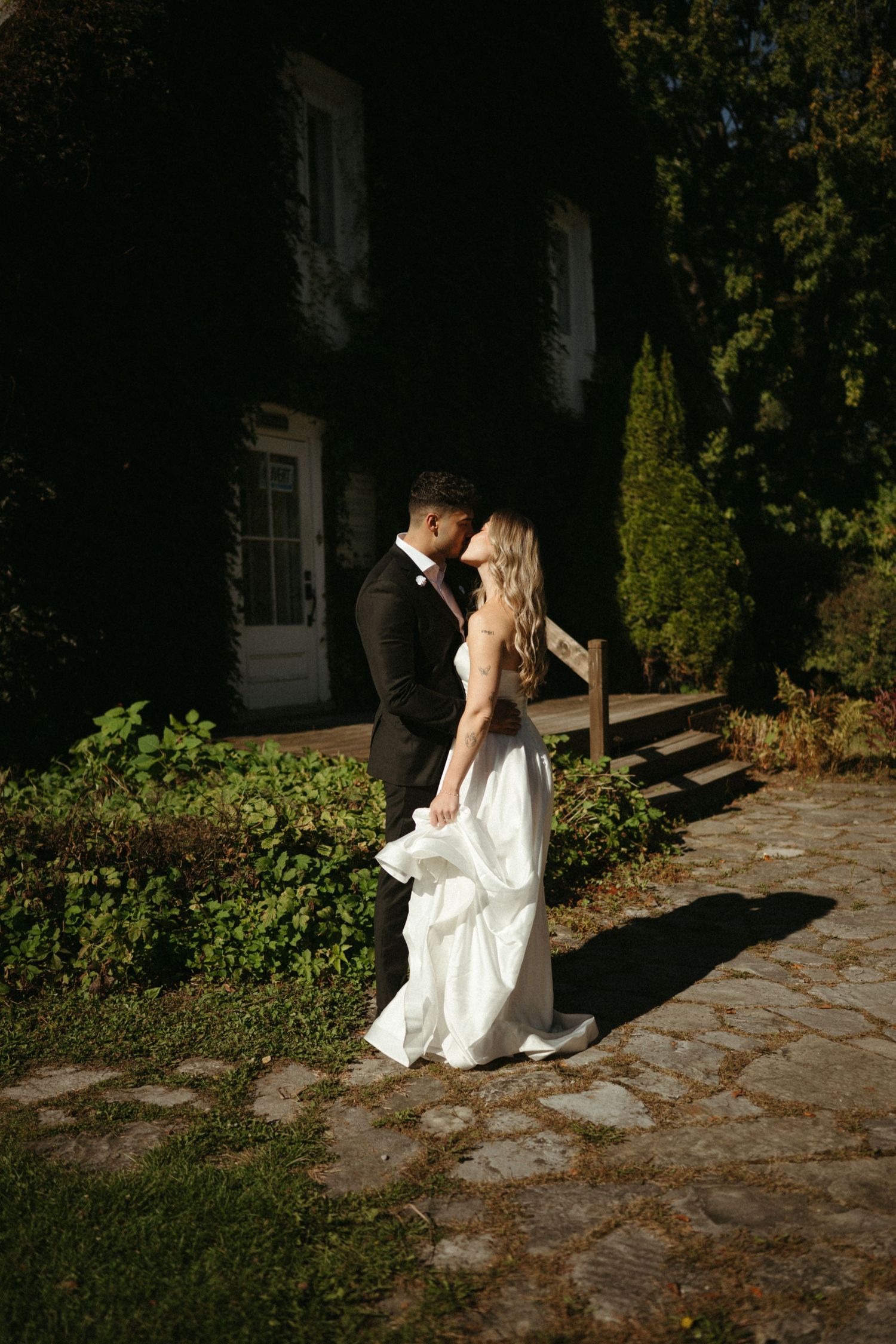 A bride and groom embracing each other in a romantic outdoor setting at night.