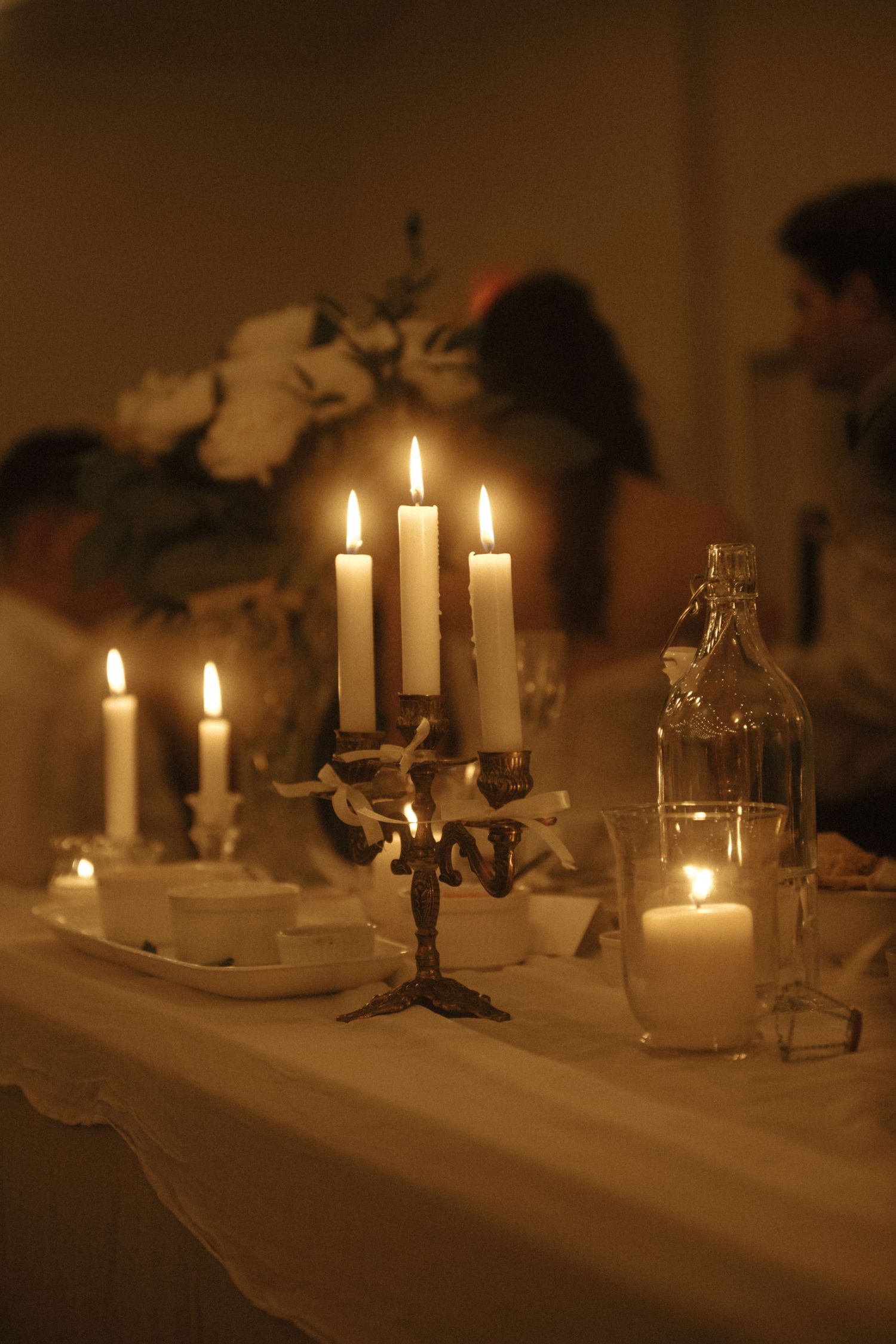 Elegant candlelit dinner table with candelabra and glowing candles casting warm light at a romantic evening event.