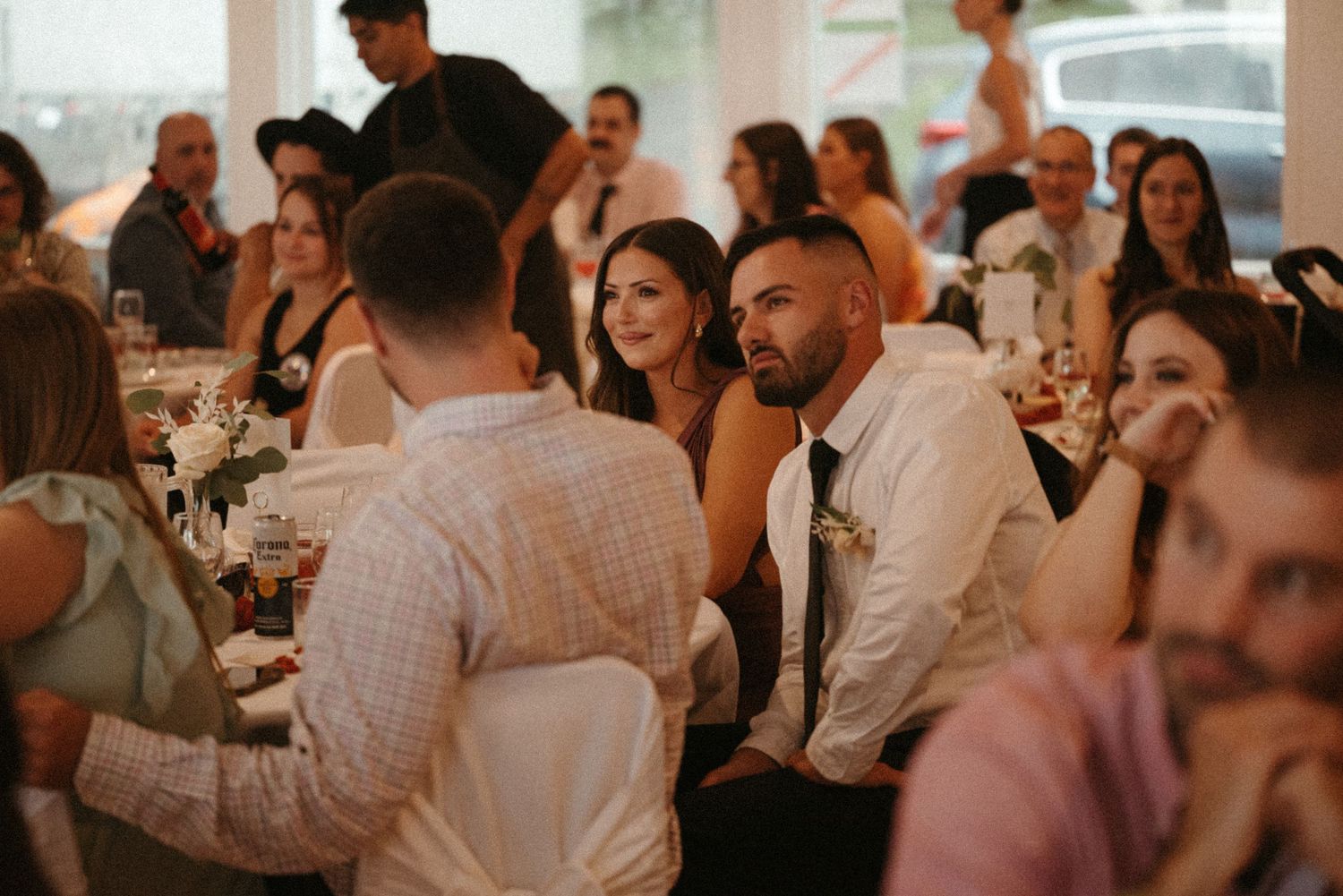 Wedding guests in formal attire socializing and enjoying the reception dinner celebration.