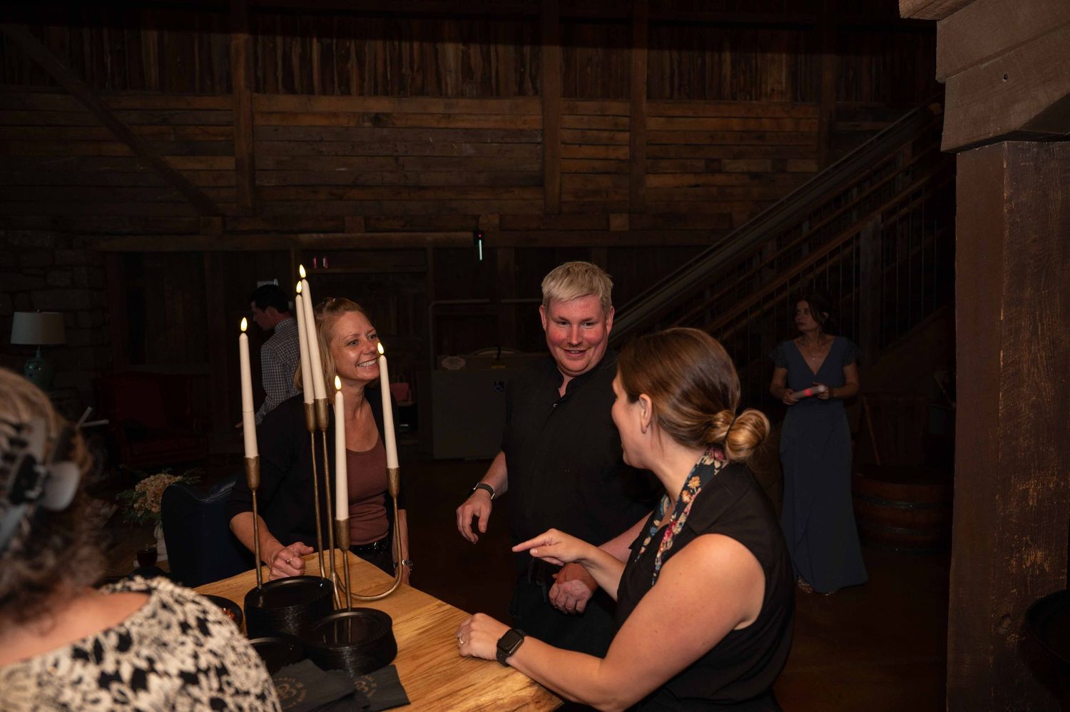 Guests at a dimly lit reception hold sparklers creating a magical nighttime atmosphere at a celebration event.