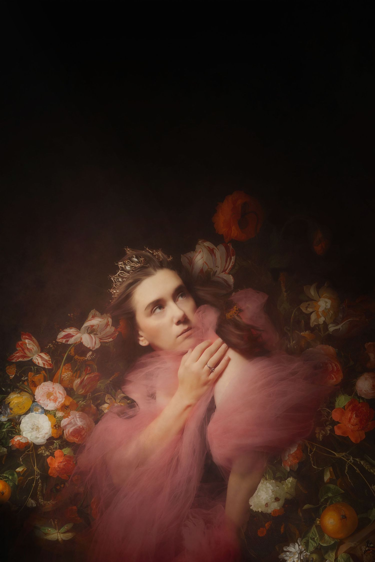 A dreamy painterly studio photo of a women with painted flowers in a painting.