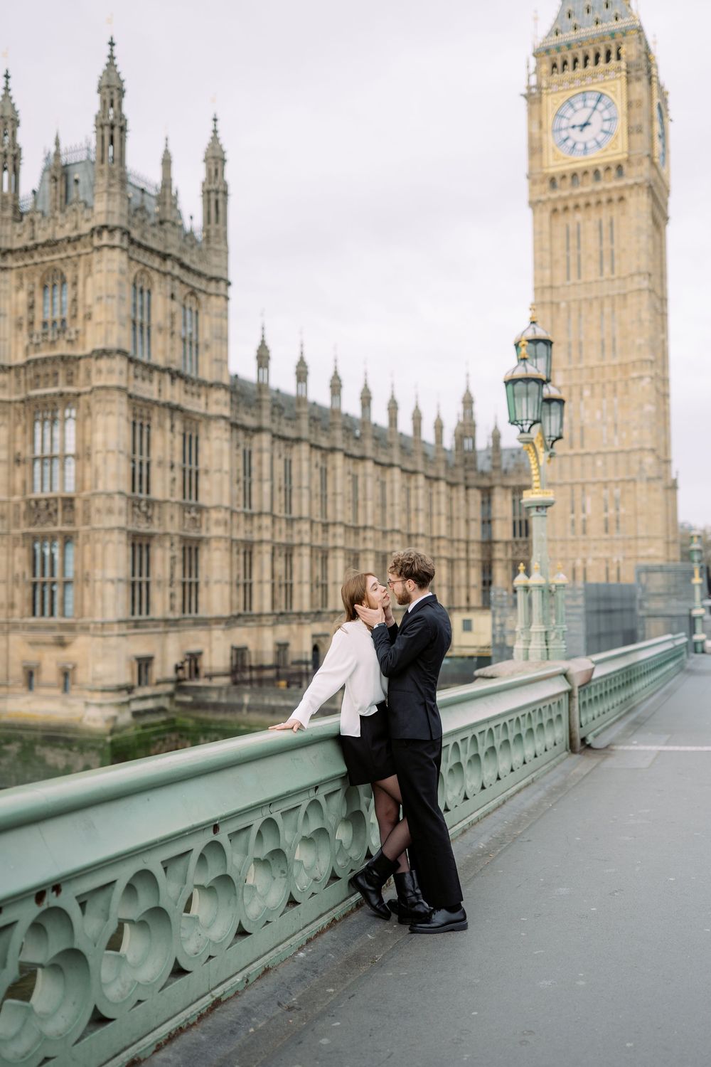 A romantic moment captured in front of London's iconic Big Ben and Houses of Parliament on Westminster Bridge.