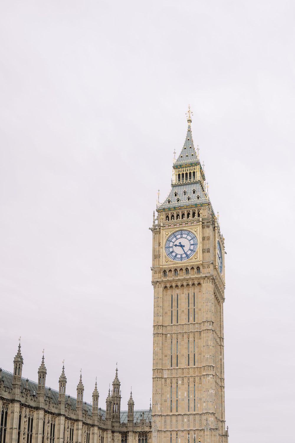 Big Ben clock tower rises against cloudy London sky at the Houses of Parliament.