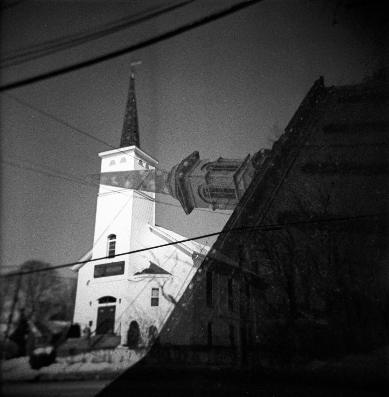 A small white church with a steeple stands silhouetted against a dark sky in a series of progressive shots.