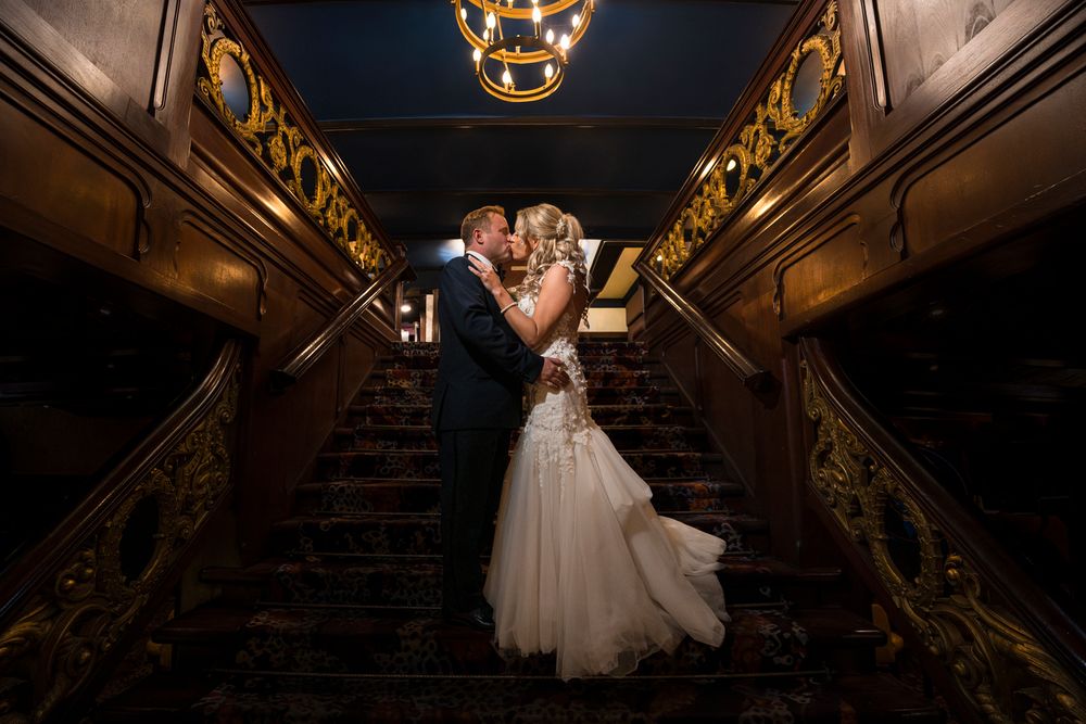 Romantic dance scene in a grand ballroom with elegant lighting and ornate gold decor.