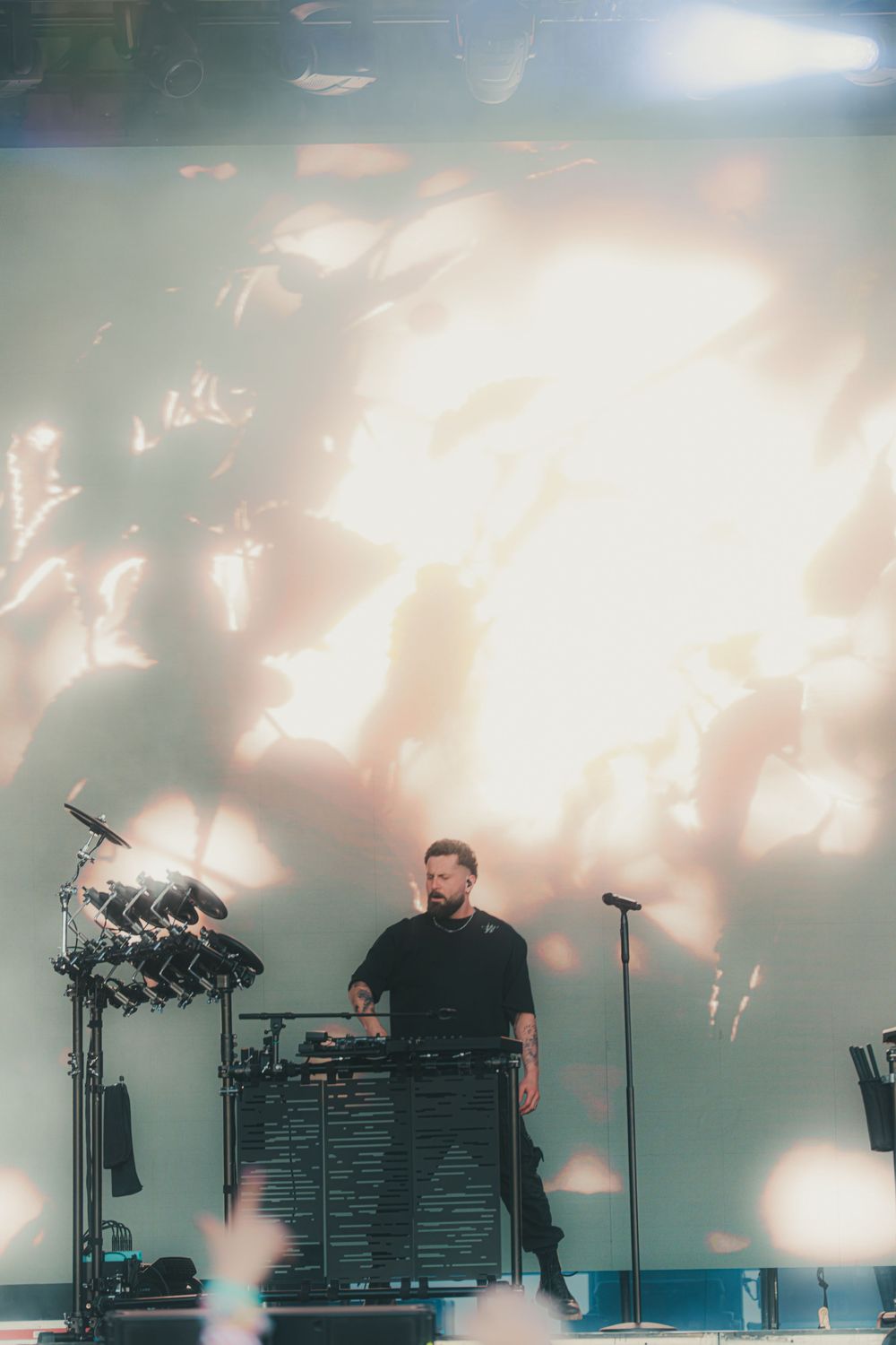 Atmospheric concert stage with dramatic lighting and silhouetted performers creating a moody ambiance during live performance.