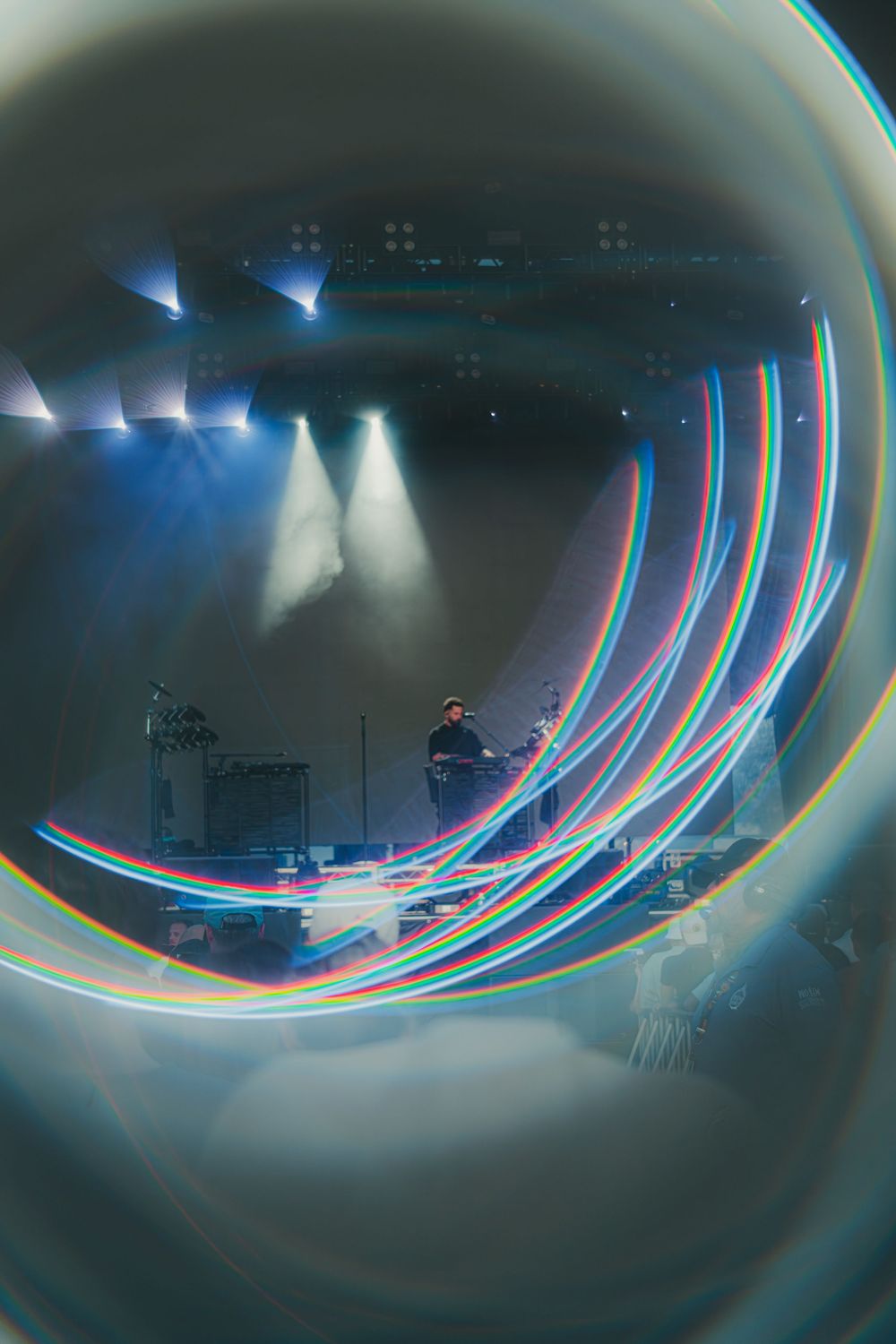 Long exposure photo showing light trails creating curved lines against a dark background in a room setting.