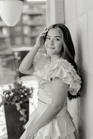 A white ruffled dress photographed in an elegant outdoor portrait setting.
