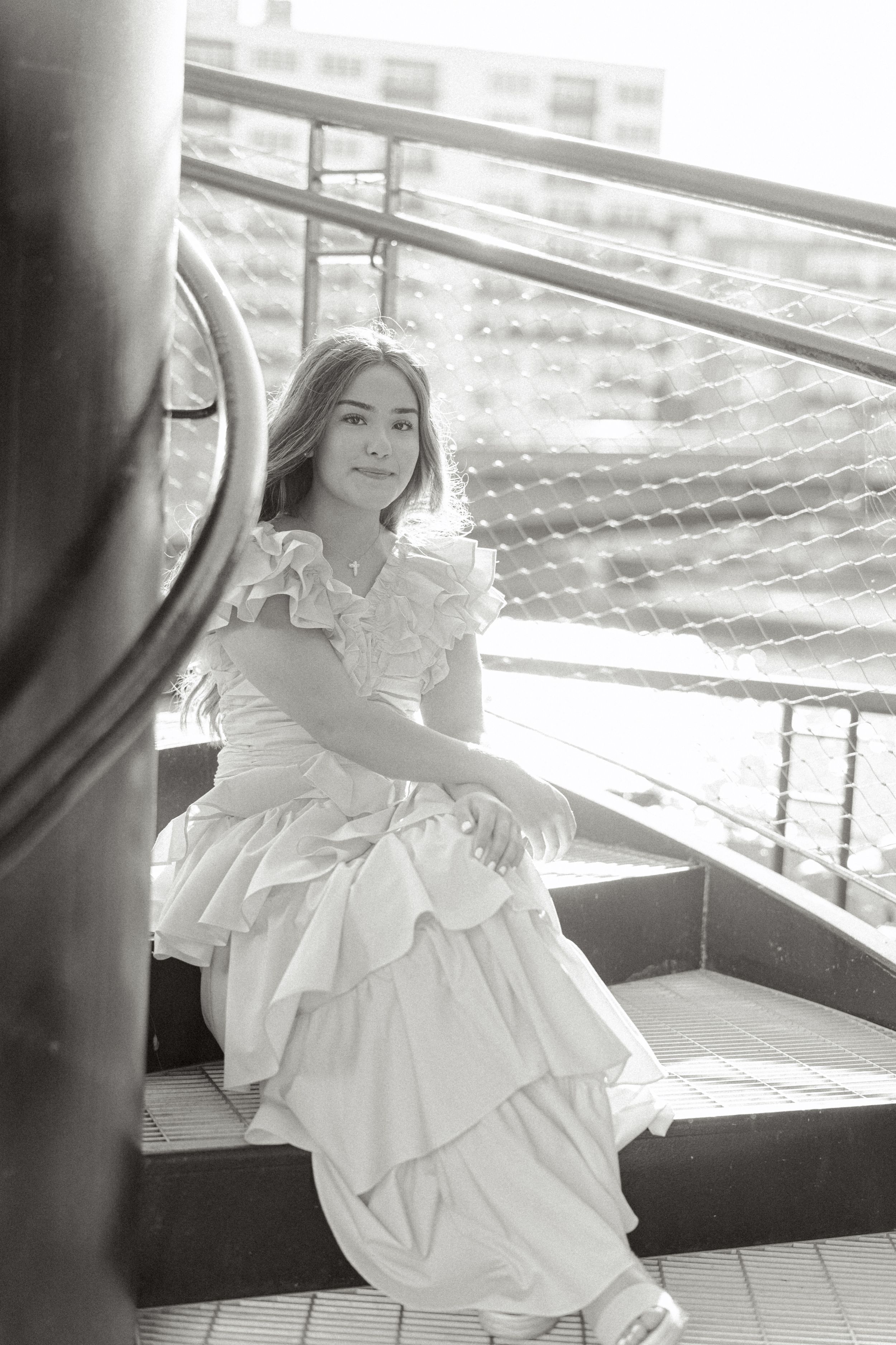 A white ruffled dress photographed in dramatic black and white on an outdoor terrace.