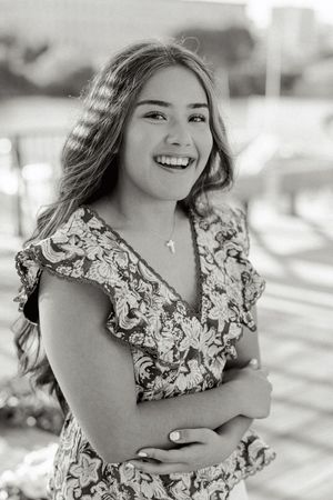 Black and white portrait wearing a floral patterned dress with ruffled details.