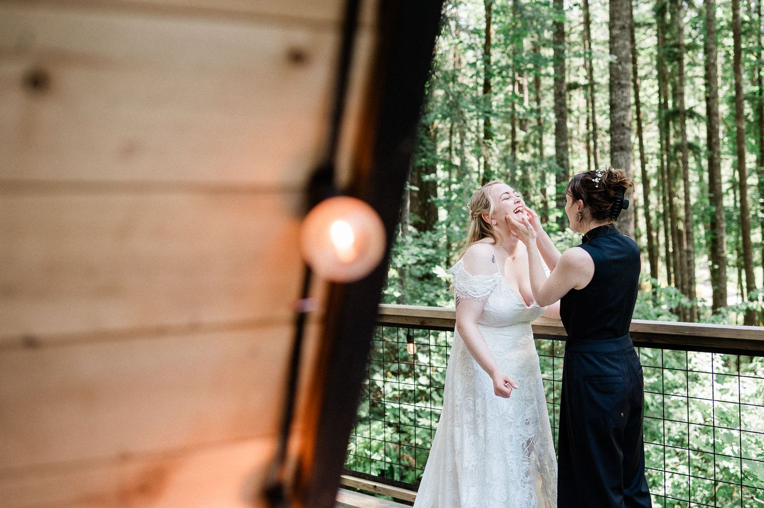 A couple shares a romantic moment during their wedding ceremony in a rustic wooden cabin surrounded by forest.