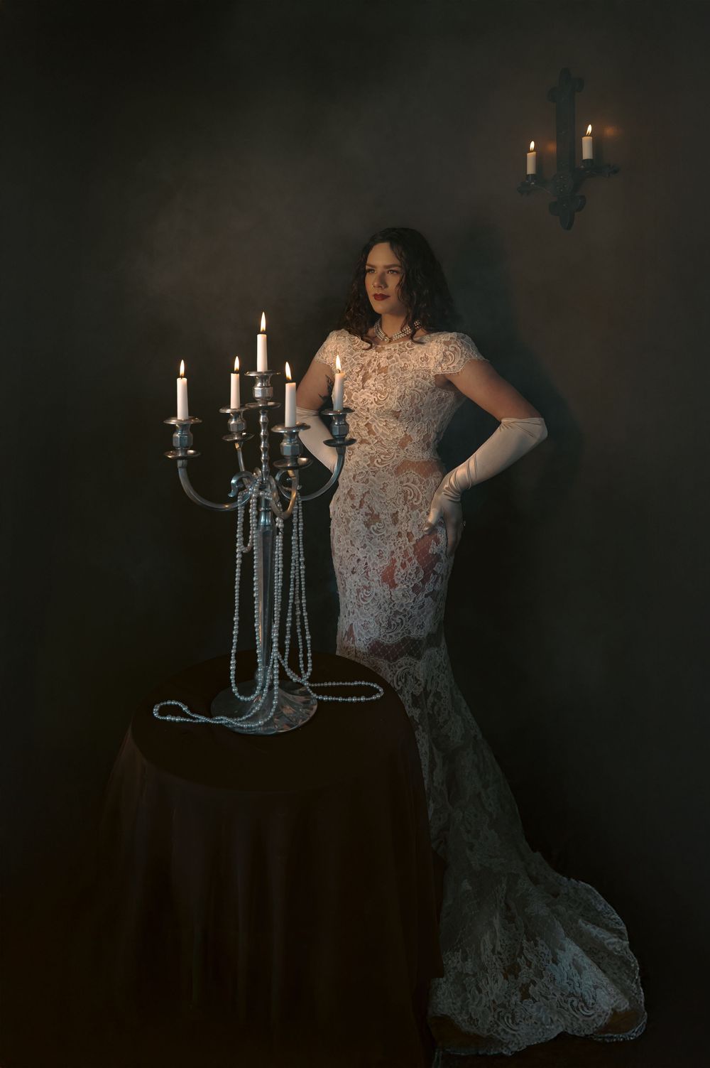 A dramatic portrait series featuring a white lace gown against a dark background with elegant candelabras.