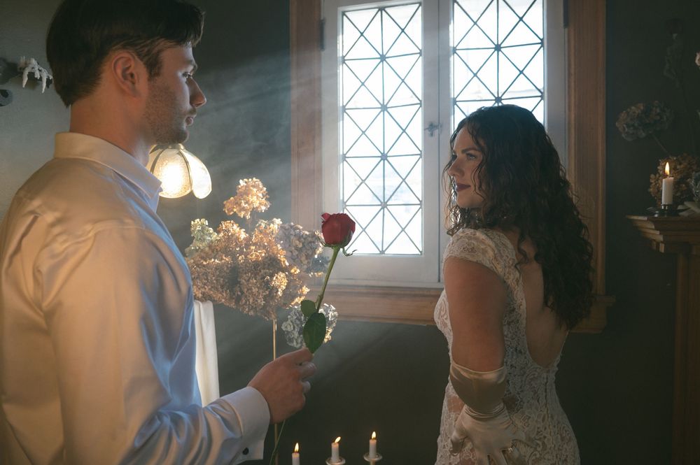 A couple shares an intimate moment during their wedding ceremony in a church with sunlight streaming through windows.