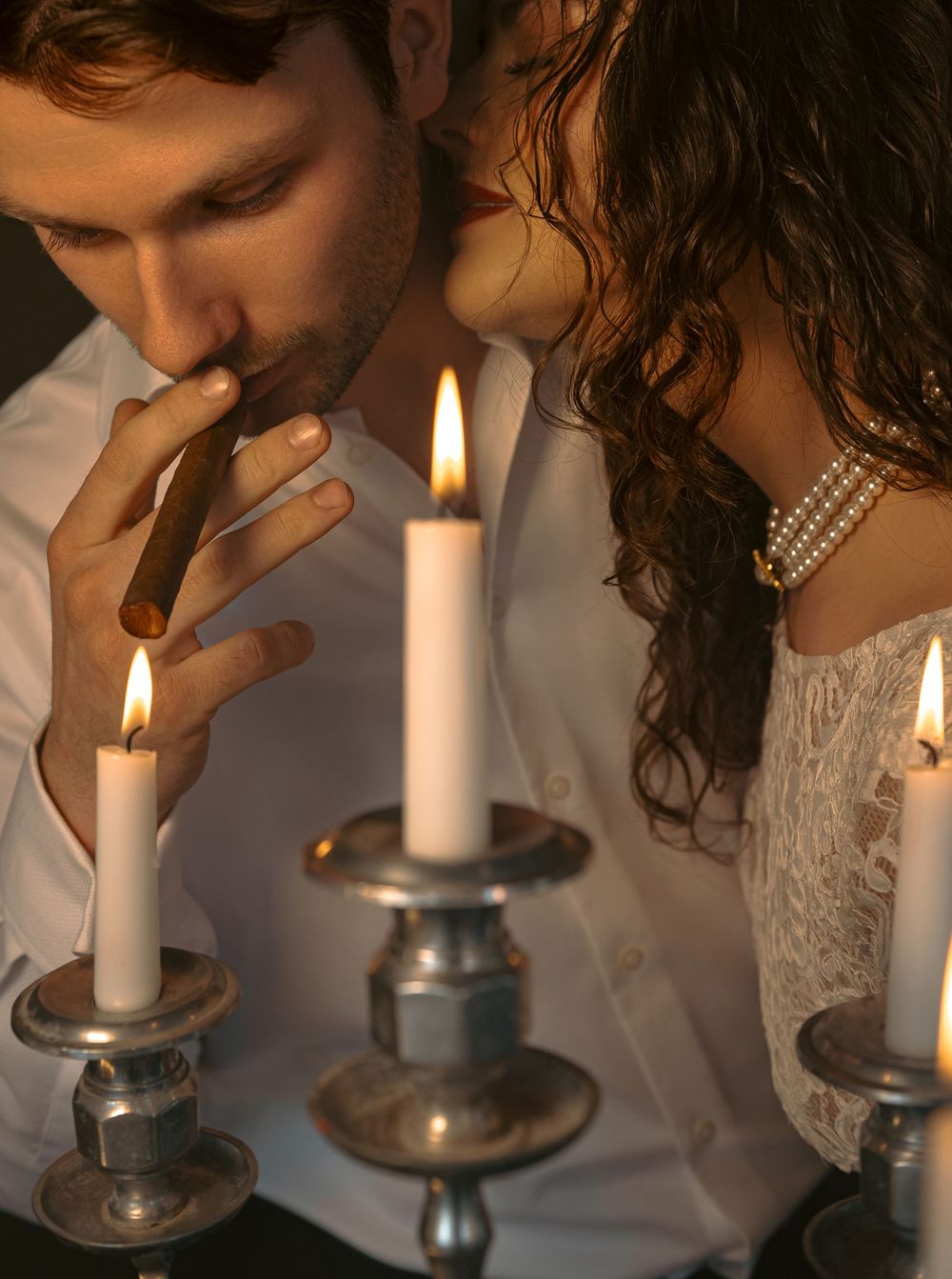 A sequence of photos showing someone blowing out a lit white candle in a glass candlestick holder.