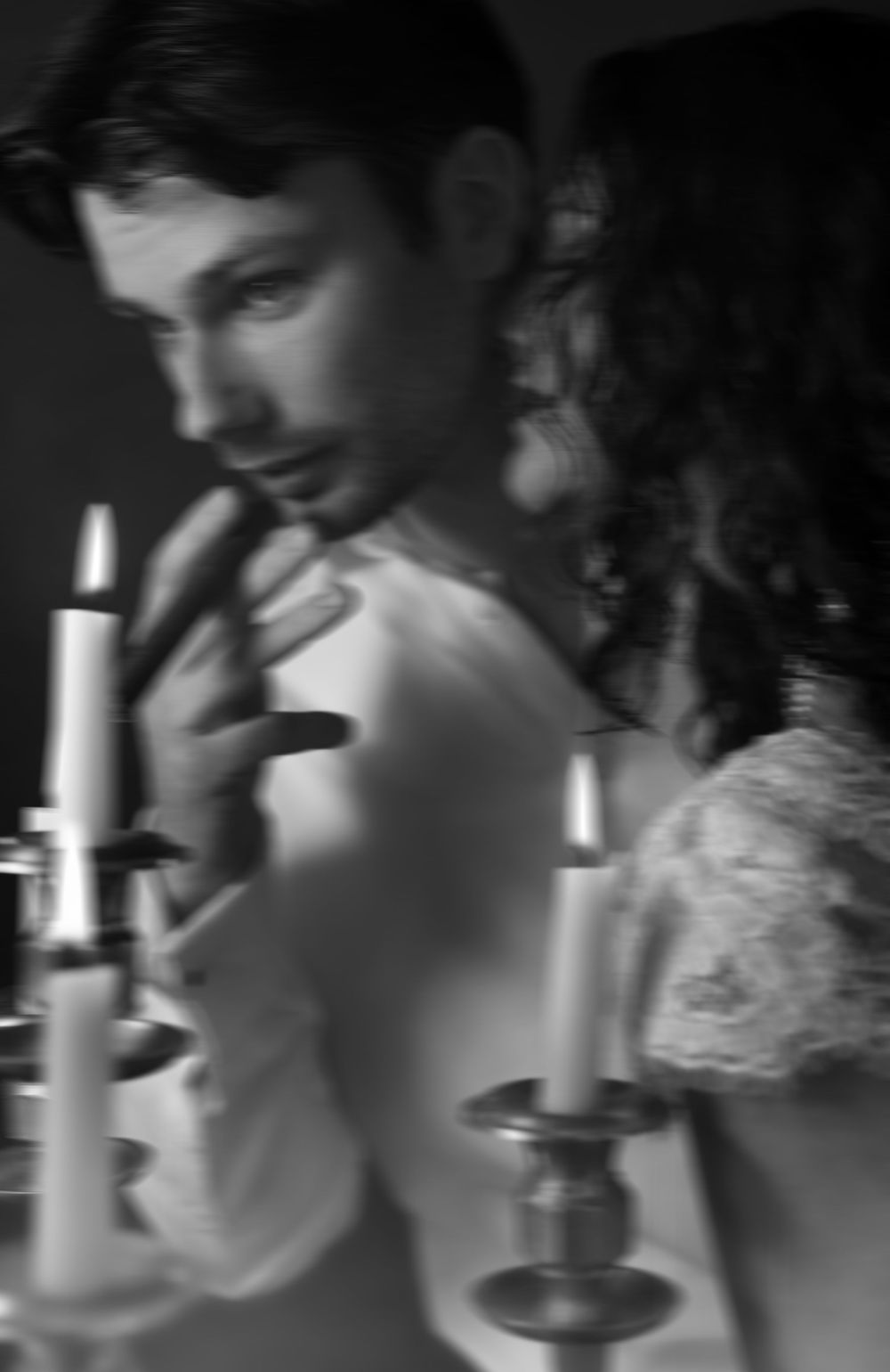 Romantic couple in candlelit setting with vintage black and white film aesthetic.