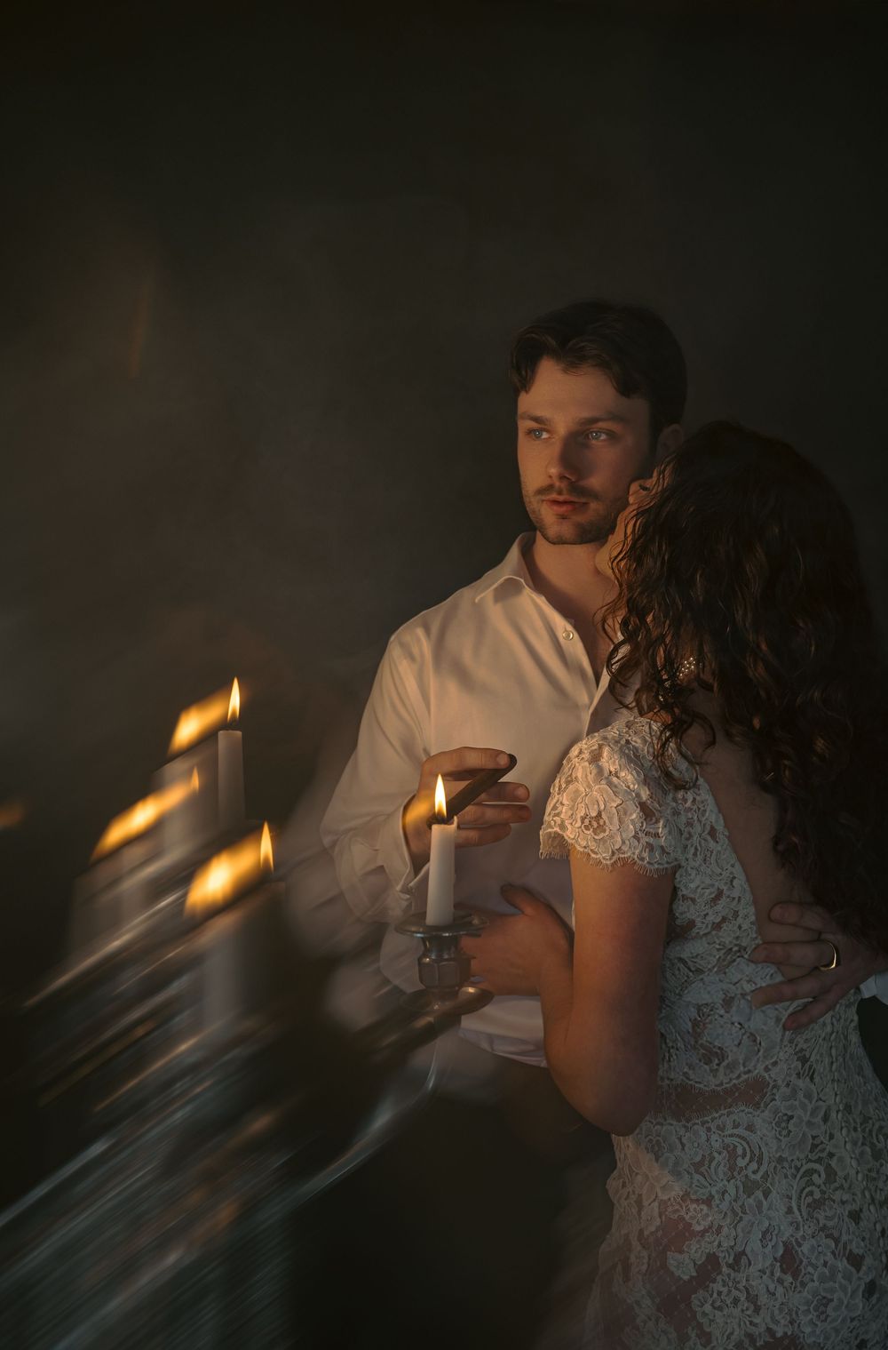 Moody candlelit photoshoot with dramatic shadows and soft lighting effects.