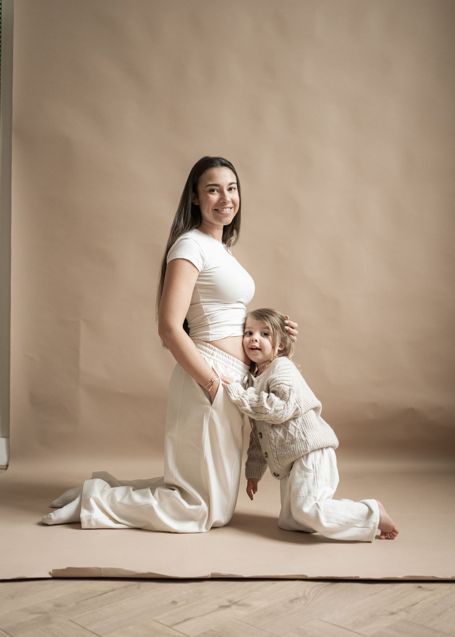 Mother and toddler with bump showing in studio photoshoot