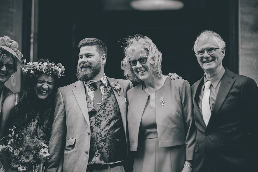 Black and white photo showing a group of people smiling together at a formal event.