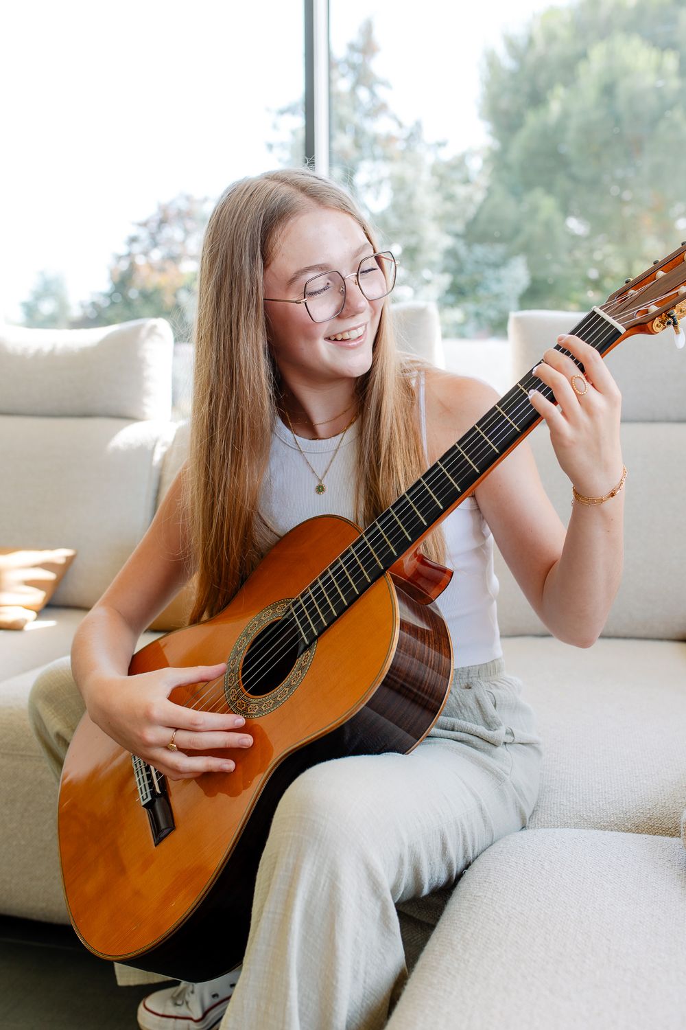 Jeune fille qui joue de la guitare chez elle pendant une séance photo en famille