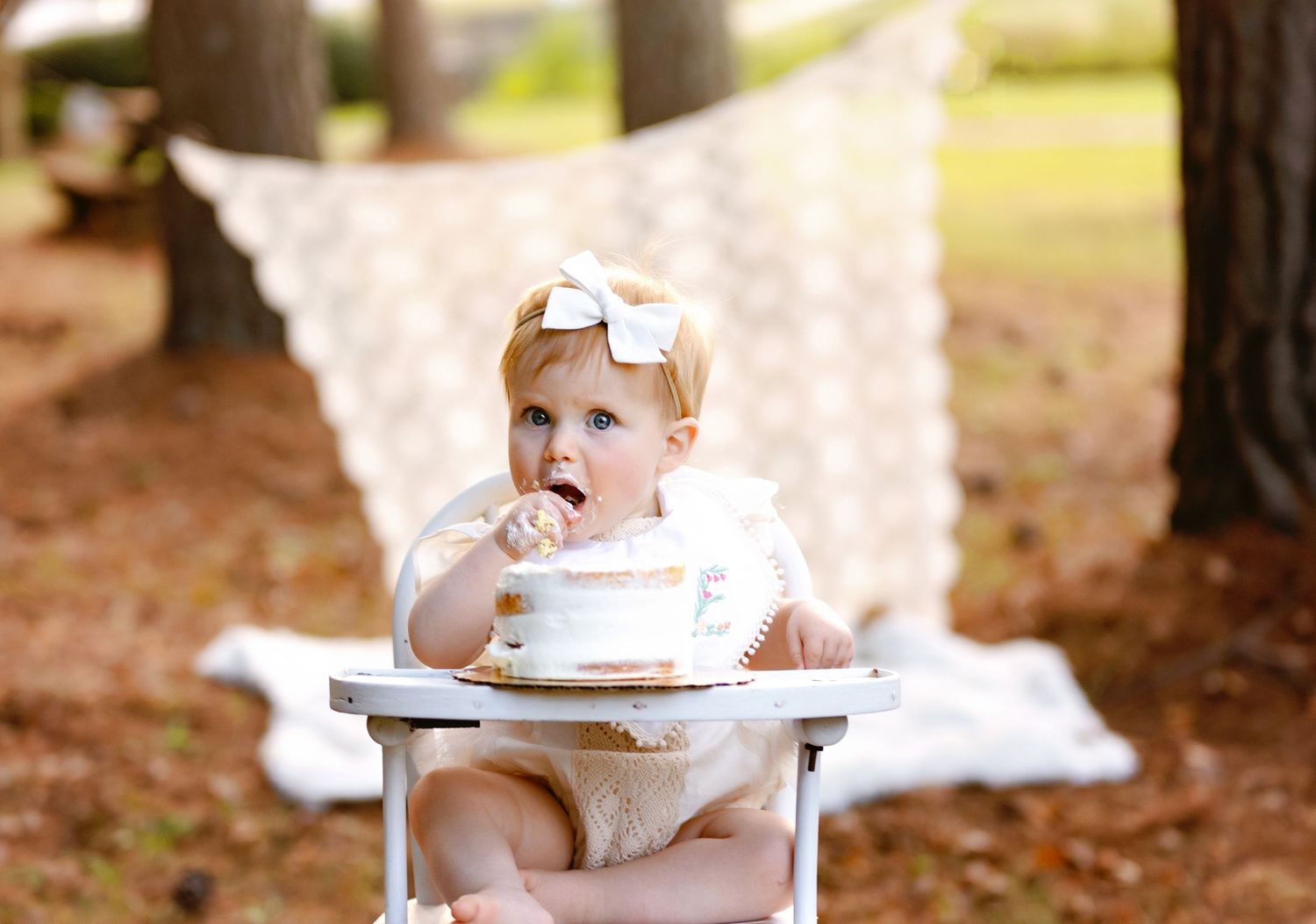 baby girl in chair eating cake. Greenville sc newborn photographer, Easley sc newborn photographer, Upstate sc newborn photographer