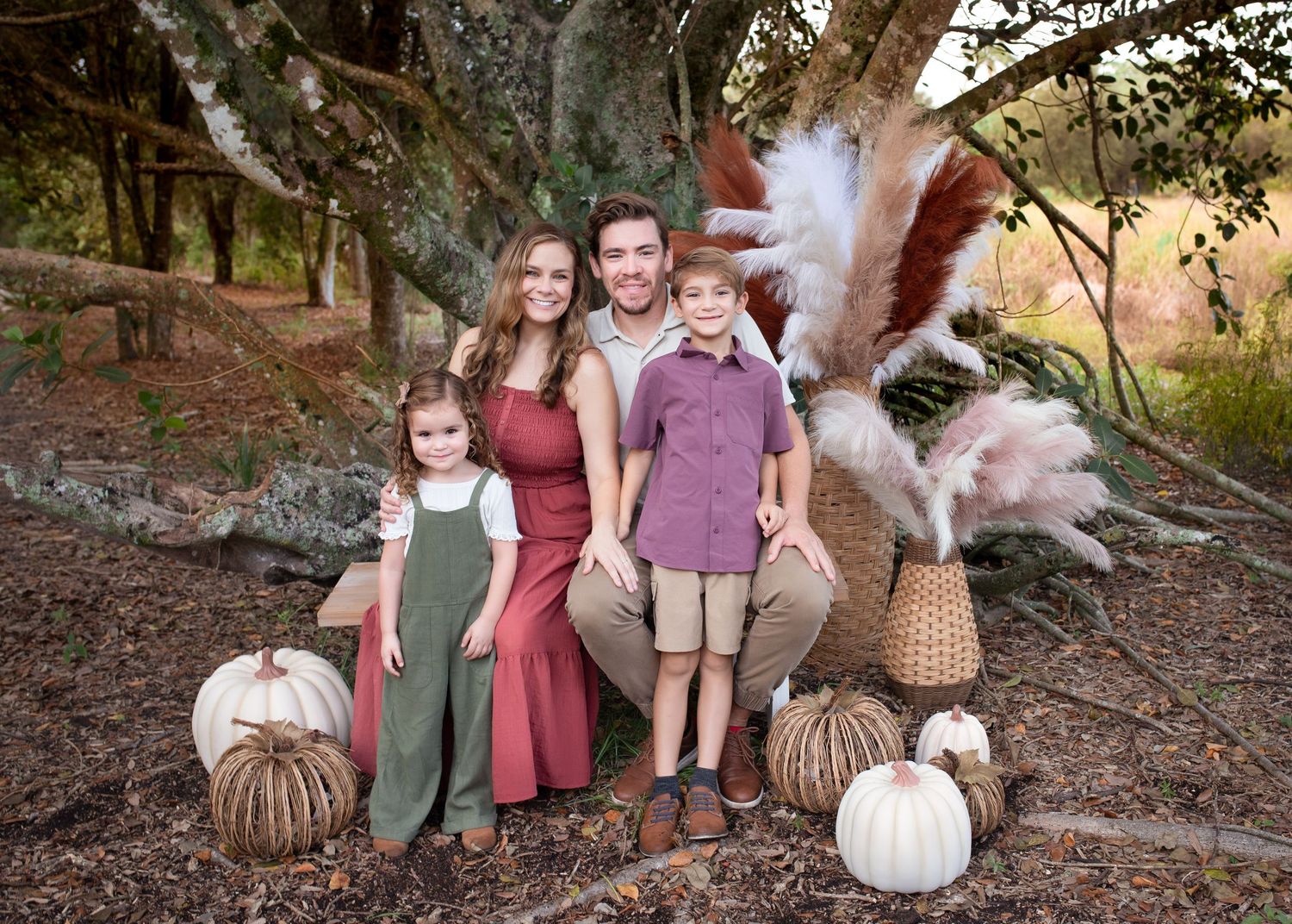 A series of fall season outdoor family portrait photos taken in a wooded setting during golden hour with coordinating earth-tone outfits.